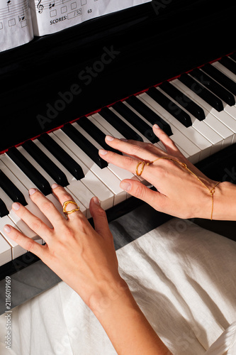 pianist female hands wearing jewelry playing piano