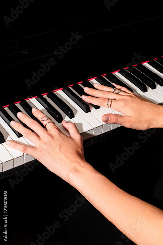 pianist female hands wearing jewelry playing piano