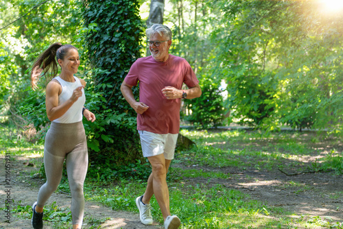 Fotografía Senior man performing an endurance running exercise alongside a fitness coach to maintain cardiovascular health, improve mobility, and promote lifelong physical activity