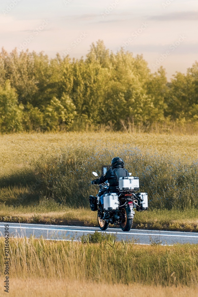 Fototapeta premium Peaceful evening motorcycle ride through green fields