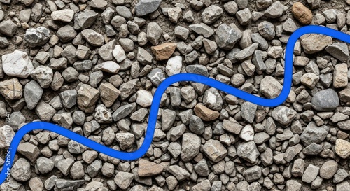Winding blue line path on grey gravel background