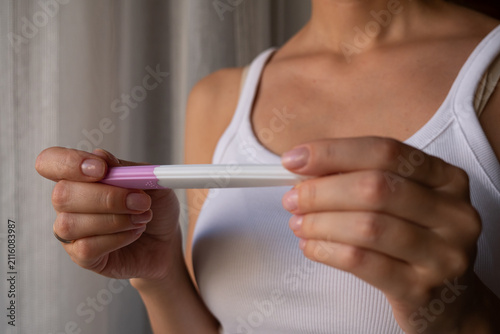 Konstfotografi Close-up of woman holding home pregnancy test with both hands, fertility and fam