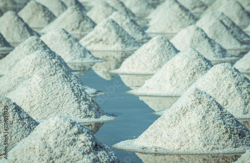 Photography Sea salt piles in traditional salt farm during solar evaporation process for natural sodium chloride production and sustainable mineral harvesting in Thailand