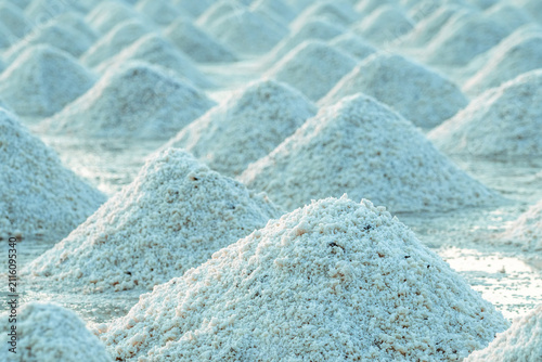 Foto Sea salt piles in traditional salt farm during solar evaporation process for natural sodium chloride production and sustainable mineral harvesting in Thailand