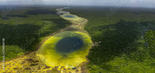 Aerial view of the Siijil Noh Ha cenote surrounded by dense tropical jungle and lush vegetation in Felipe Carrillo Puerto, Quintana Roo, Mexico.
