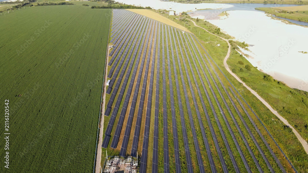 Obraz premium Aerial view of solar farm producing clean energy next to agricultural field and natural landscape, illustrating sustainability