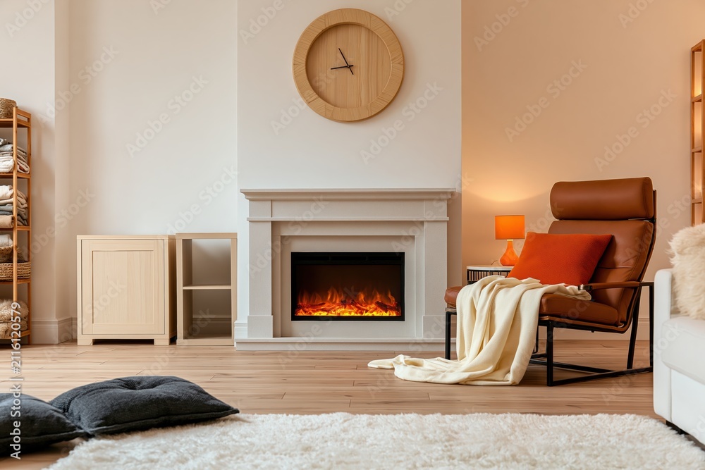 Obraz premium Interior of a modern living room with a cozy leather armchair and electric fireplace