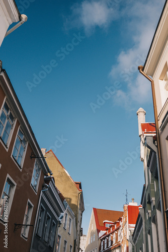Fotografie Tall buildings meet blue sky in a city street during daytime