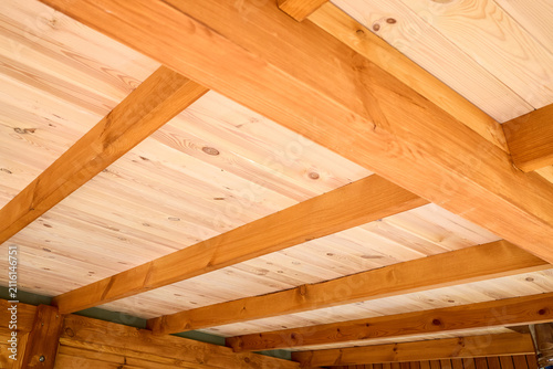 Obraz na plátně Interior view showcases rustic wooden ceiling crafted from natural Douglas fir timber planks with parallel exposed beams creating warm geometric architectural pattern inside cottage log home