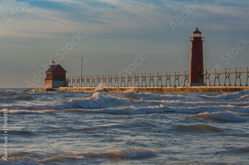 Landscape of the Grand Haven, Michigan Lighthouse at sunset with splashing waves, Lake Michigan, USA