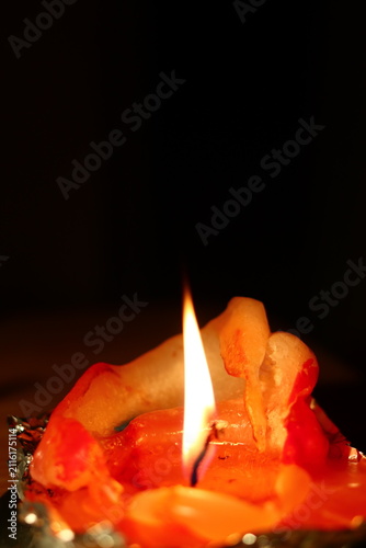 A burning candle in the form of a figurine.