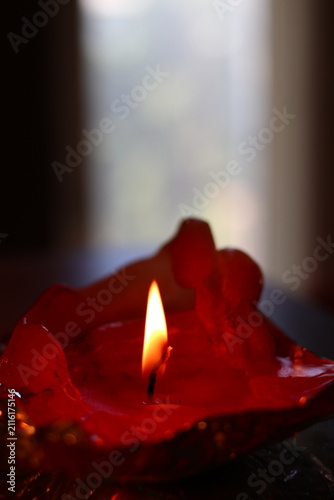 A burning candle in the form of a figurine.