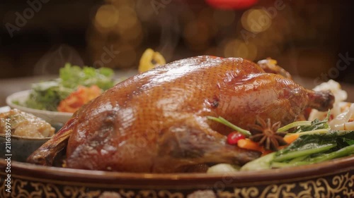 Freshly roasted whole duck steaming on a decorative platter