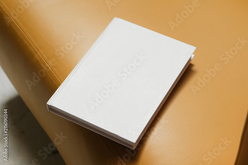empty book mockup on soft chair indoors