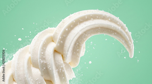 Frozen yogurt swirl in motion with scattered sugar crystals isolated on a solid mint green background
