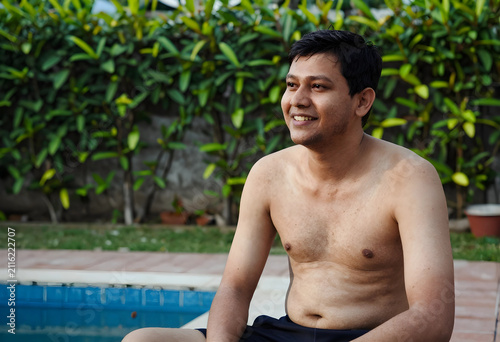 Smiling shirtless asian man...