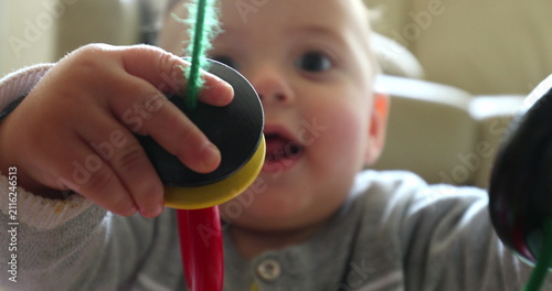Canvas Print Toddler baby playing with toy happy infant holding grabbing trinket