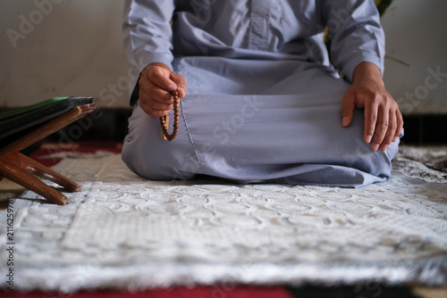 Fotografía Close-up of hands reciting dhikr using prayer beads with a blurred background