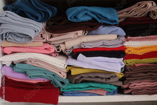 Konstfotografi Neatly stacked on the shelf, the colorful headscarves or hijabs show soft textil