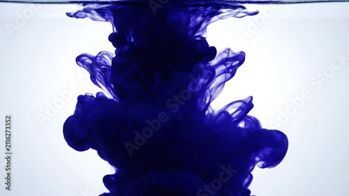 Blue ink cloud spreading in clear water background.