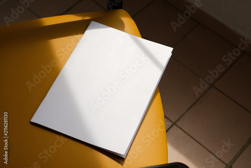 empty magazine mockup on soft chair indoors