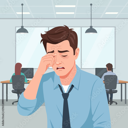 Exhausted Office Worker Rubbing Tired Eyes In A Modern Workspace
