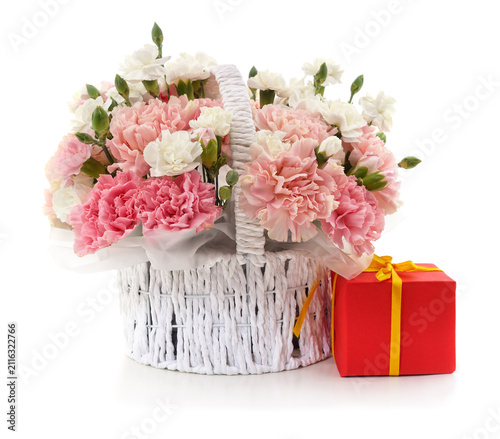Basket of carnations with gift box on white background.