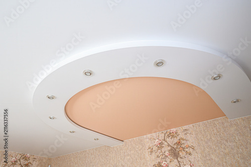 Cuadro en lienzo two‑level gypsum board ceiling features a curved recess with a peach‑colored pan