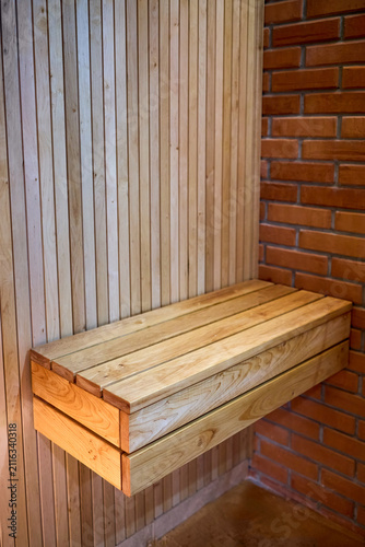 Fotografía floating wooden alder sauna bench installed against light timber slatted panel w