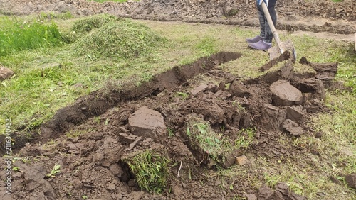 Ground Preparation Process Deep cut in the soil with stacked grass blocks alongside for gardening magazines pipeline installation manuals and builder websites