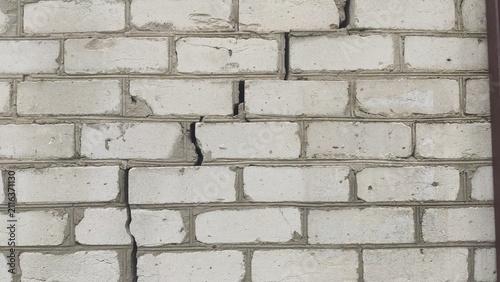 Obraz na plátne Cracked Brickwork Facade White silicate blocks displaying a long horizontal stru