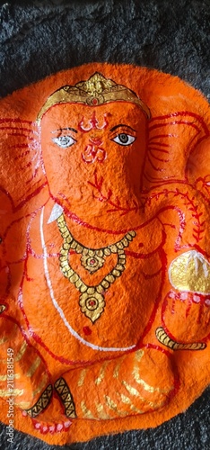 Saffron Painted Lord Ganesha Deity Idol Adorned with Golden Ornaments Inside Ancient Temple Shrine