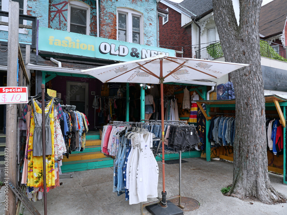Fototapeta premium Vintage clothing store with outdoor display on sidewalk, Kensington Market bazaar, Toronto