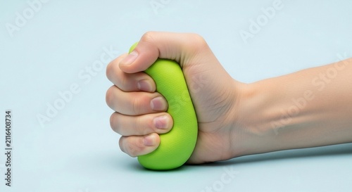 Hand squeezing a bright green rehabilitation grip stress ball to relieve tension