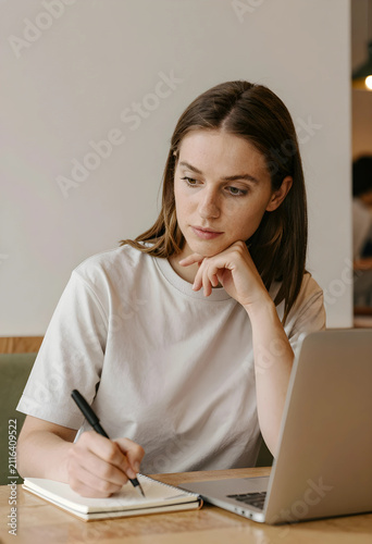 Young woman writing notes i...