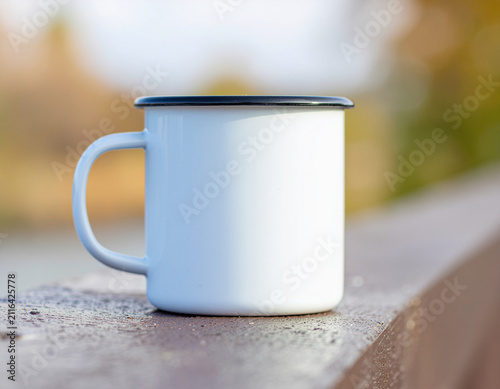 A plain white ceramic mug sits on a concrete windowsill illuminated by soft morning daylight, creating a calm minimalist lifestyle scene with generous copy space