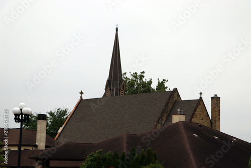 Canvas Print Historic church roof and steeple spire against cloudy sky