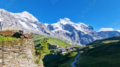 Swiss flag on wooden view platform Kleine Scheidegg Switzerland 4K. Hiking trail towards railway station with snowy peaks in background. Scenic Bernese Oberland travel b-roll stock video
