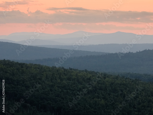 Nature landscape with rolling hills and forest at sunset, tranquil outdoor scene