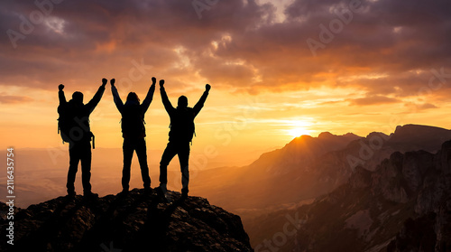Silhouette of Three Hikers Celebrating Victory on Mountain Peak at Golden Sunset