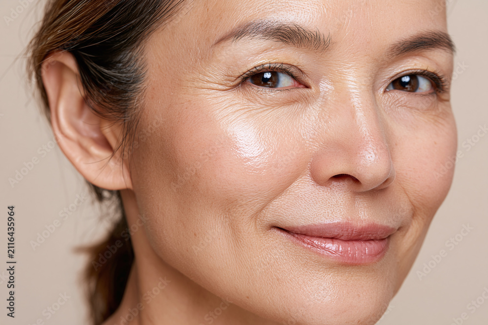 Obraz premium Glowing middle aged Japanese woman portrait smiling naturally with radiant skin and subtle makeup