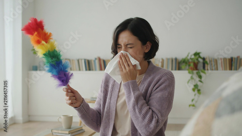 Woman Sneezing from Dust While House Cleaning with Feather Duster