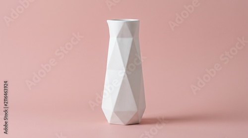 Minimalist white ceramic vase with a modern geometric faceted design isolated on a clean pastel pink background. Perfect for elegant home decor and stock design concepts.