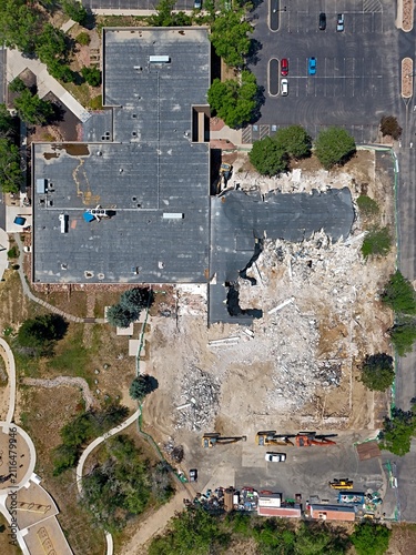 Aerial view of a building demolition site with heavy machinery, debris, and partial structure remaining in Thornton, Colorado, United States.