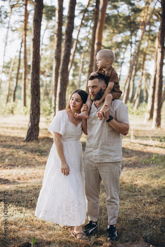 Young parents with their small child having a walk in nature, spending quality time together outside