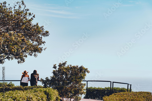 Back view of a tourist couple admiring the Pacific Ocean horizon from a viewpoint in Barranco, Lima