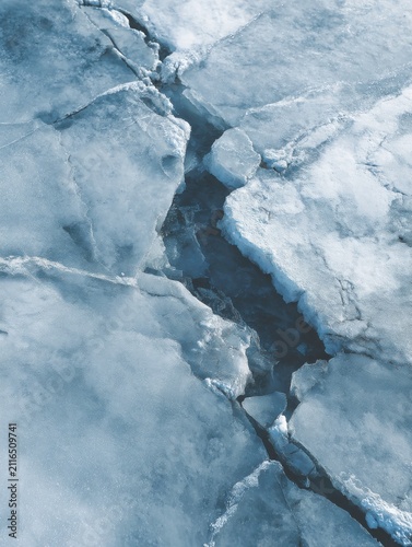 Aerial View of Cracked Ice Formation on Frozen Lake Surface in Winter Season Cold Weather Climate Change Concept
