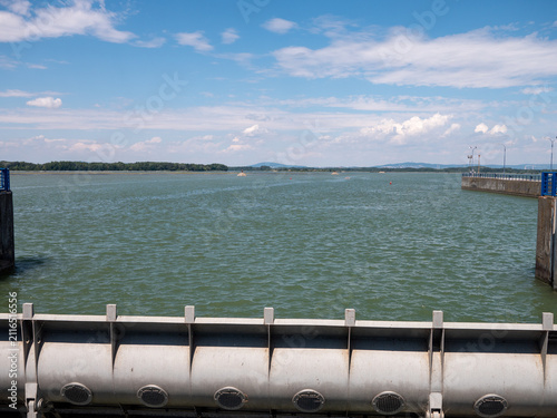 Konstfotografi Steel lock gate at the Čunovo navigation lock, overlooking the Gabčíkovo reservoir under a blue summer sky in southwestern Slovakia