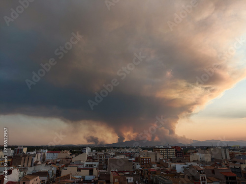 Wildfire smoke spreading over almassora city buildings at sunset