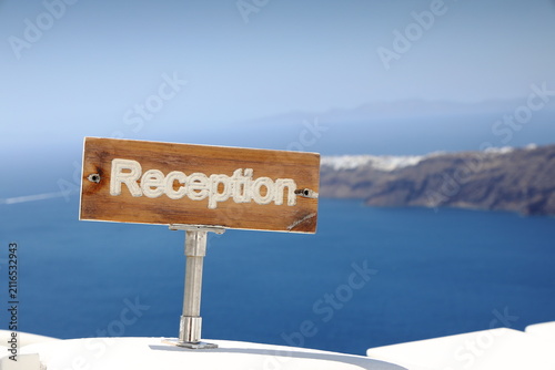 Rustic welcome sign with the ocean in the background, in Santorini. Greece